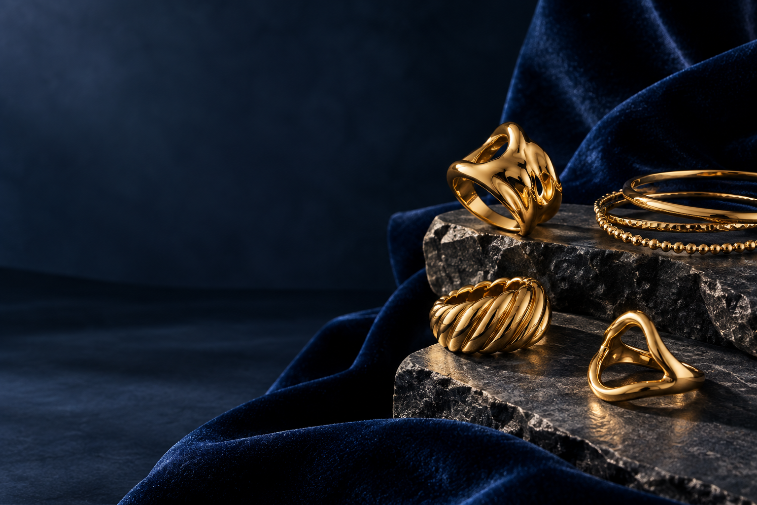 Gold-tone rings and bangles on blue velvet
